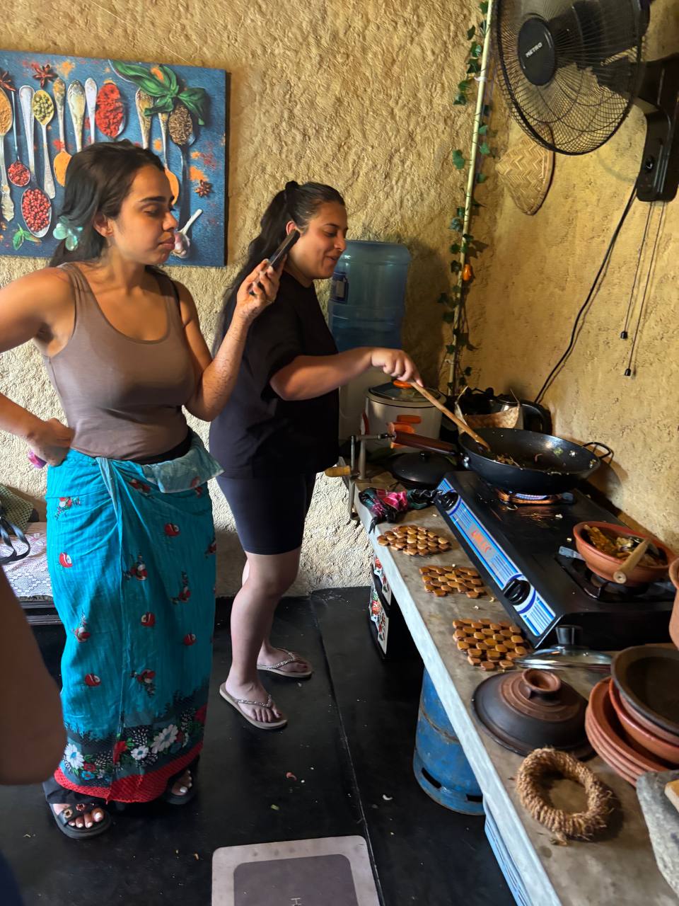 Guests learning the art of stir-frying curries over the stove